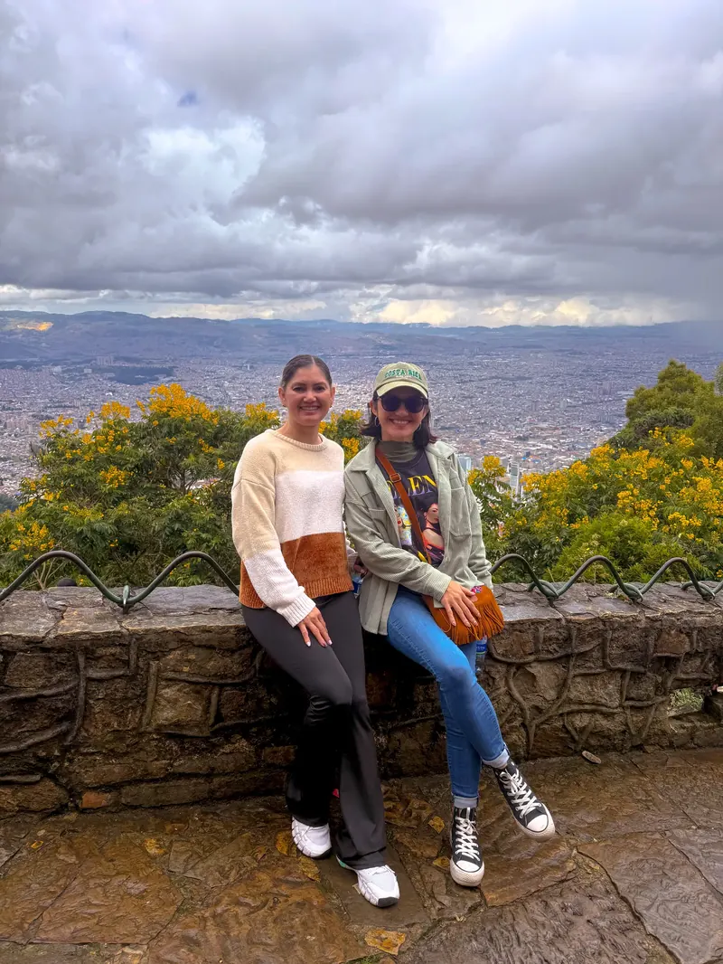 Dos viajeras en el mirador de Monserrate, con Bogotá extendida detrás
