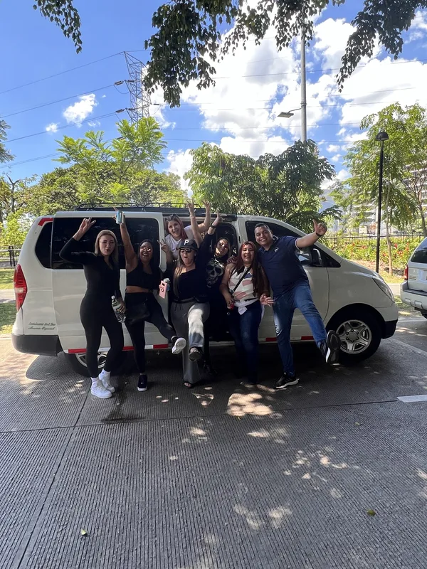 Un grupo posa junto a la van antes de salir de viaje