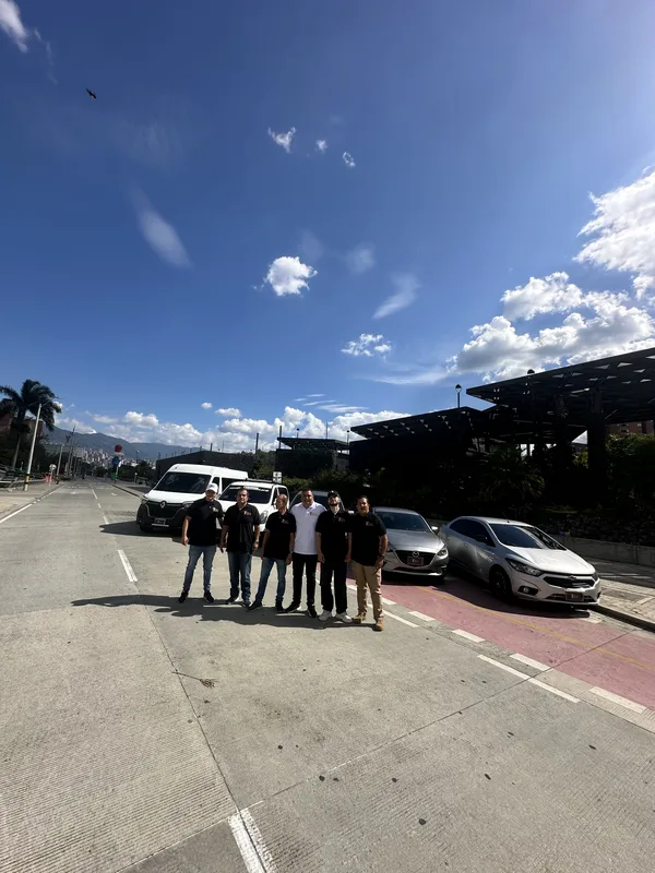 Equipo y vehículos alineados en una calle bajo el cielo azul