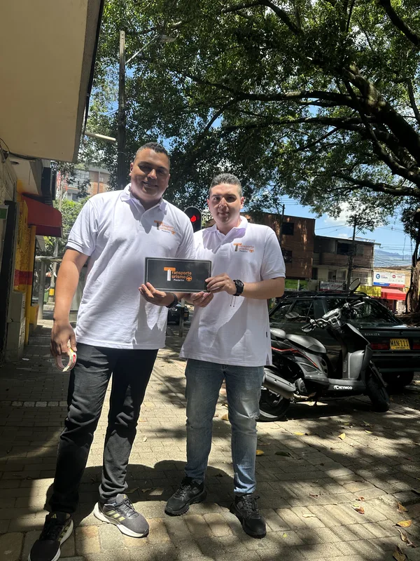 Dos integrantes del equipo con camiseta blanca en la puerta de la oficina