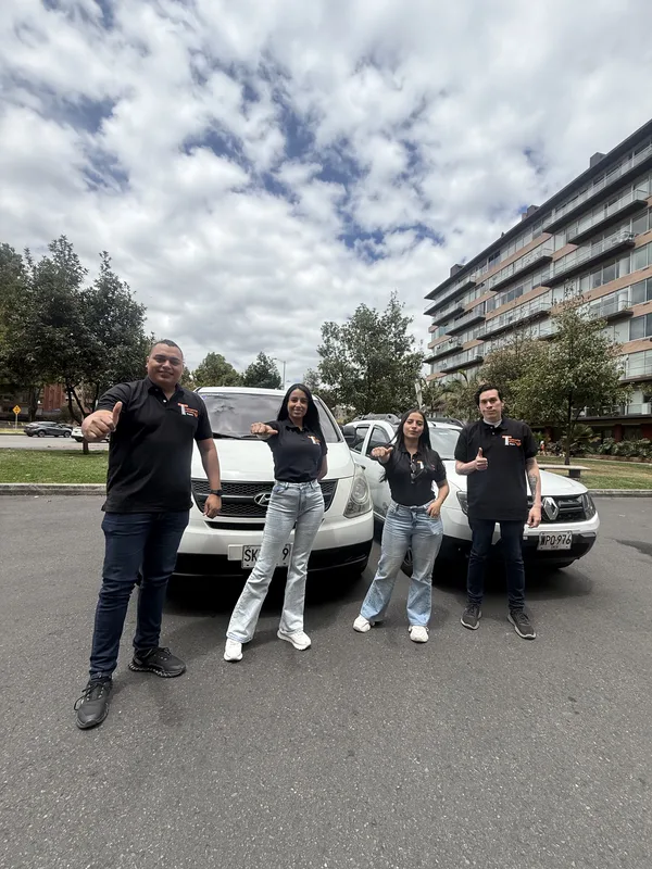 Cuatro integrantes del equipo junto a los vehículos