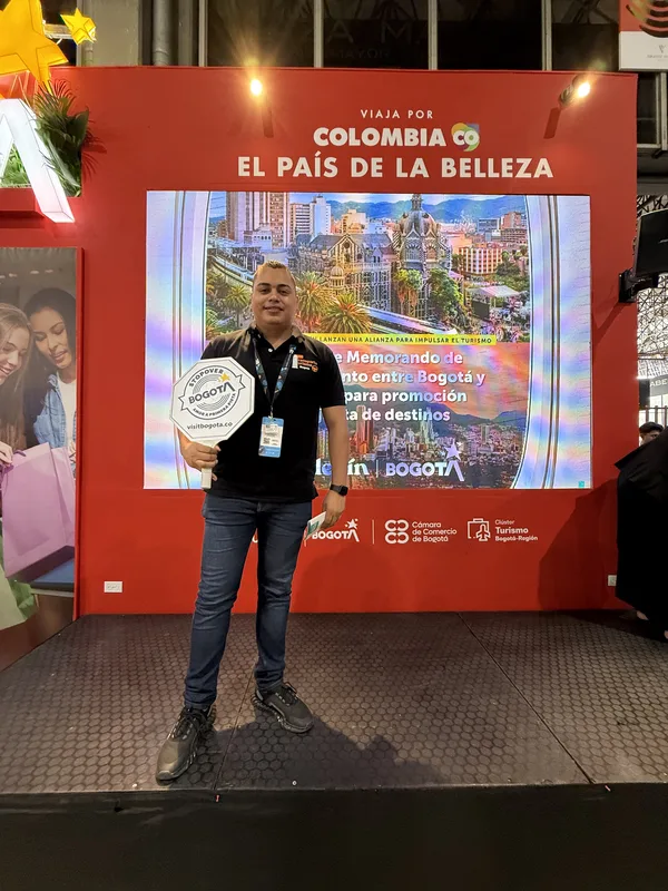 En una feria de turismo, frente al stand de Colombia